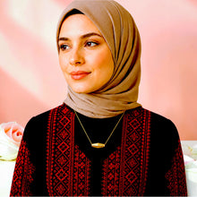 Olive bead necklace worn with a black and red embroidered dress