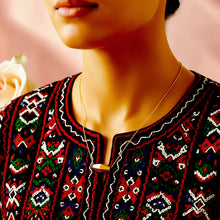 Medium-length olive bead necklace styled with an embroidered dress