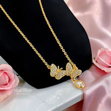 Close-up of an 18K gold plated double butterfly necklace with zircon-set wings and a teardrop charm by Misk Shop.