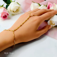 Close-up of a minimal gold hand chain with flat rectangular details
