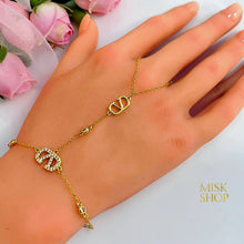 Close-up of gold VLogo motifs and high-transparency zircon on a hand chain