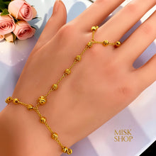 Close-up of textured gold bubble beads on a delicate hand chain