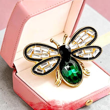 Handcrafted 21K gold color bee brooch with baguette zircon wings, black enamel details and emerald green crystal by Misk Shop.