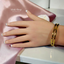 Reversible 21K gold plated titanium steel Atlas-inspired bangle with polished gold side and sparkling zircon side from Misk Shop.