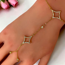 Close-up of open four-petal zircon motifs on a gold plated hand chain