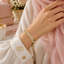 Gold connected three-row bracelet worn on wrist with zircon center