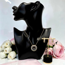 Boucheron-inspired gold plated necklace and hoop earrings set displayed with flowers