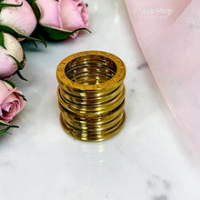 Close-up of polished layered wide band ring in gold tone