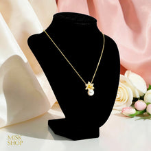 Gold-plated cultured pearl floral necklace displayed on a black bust