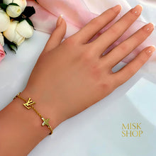 18K gold-plated monogram-inspired chain bracelet worn on the wrist