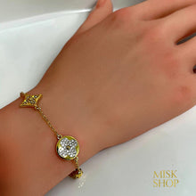 Close-up of round and star-shaped floral zircon motifs on a gold-plated bracelet
