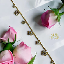 Close-up of alternating four-petal high-transparency zircon flower motifs on a gold-plated chain bracelet