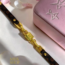 Close-up of LV-inspired monogram lock bracelet with gold-plated details