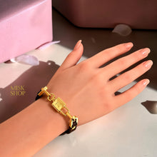 LV-inspired monogram lock adjustable brown leather bracelet worn on wrist