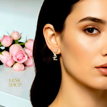 18K gold plated interlocking YSL letter earrings worn on a model