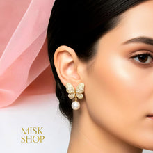 18K yellow gold plated butterfly earrings with high-transparency zircon and a cultured pearl drop worn on a model
