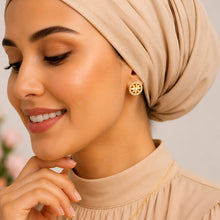 Close-up of a compass star earring on a model