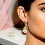 Gold plated cultured pearl drop earring with high-transparency zircon floral cap worn on a model