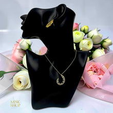 Gold open teardrop jewelry set on display