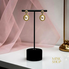 Pair of oval cultured pearl and high-transparency zircon drop earrings on a black display stand