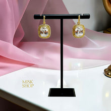 Pair of 18K gold plated rectangular high-transparency zircon drop earrings on a display stand