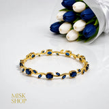 Gold-tone tulip vine bracelet with navy zircon stones