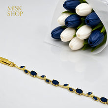 Close-up of gold-tone tulip vine bracelet with navy zircon stones