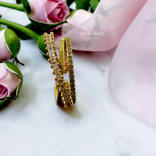 Side view of a gold open crossover ring with clear stone detailing