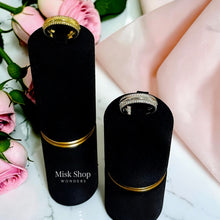 Gold and silver open wedding rings displayed on black stands