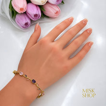 Gold-tone pink and lilac zircon bracelet styled on the wrist