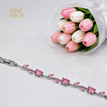 Close-up of silver-tone bracelet with round and leaf-cut pink zircon stones