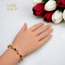Gold-tone red and green zircon tulip bracelet styled on the wrist