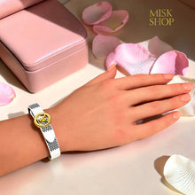 White reversible LV-inspired leather bracelet showing round logo side
