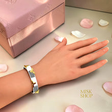 White reversible LV-inspired leather bracelet showing monogram side