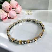 Two-tone zircon X-detail bangle laid flat