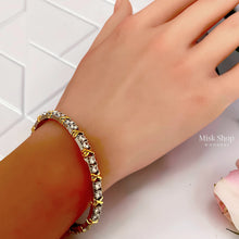 Two-tone zircon X-detail bangle worn on wrist