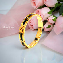 Close-up of Misk Shop Tory Burch inspired black enamel bangle with 18K gold plating