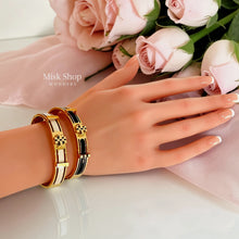 Misk Shop Tory Burch inspired ivory white and black enamel bangles styled together on a hand