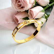 Close-up of Misk Shop Tory Burch inspired ivory white enamel bangle with 18K gold plating