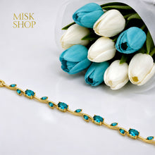 Close-up of gold-tone tulip vine bracelet with turquoise zircon stones