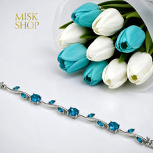 Close-up of silver-tone tulip vine bracelet with turquoise zircon stones