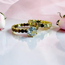 Close-up of gold twin ring set with high-clarity zircon stones